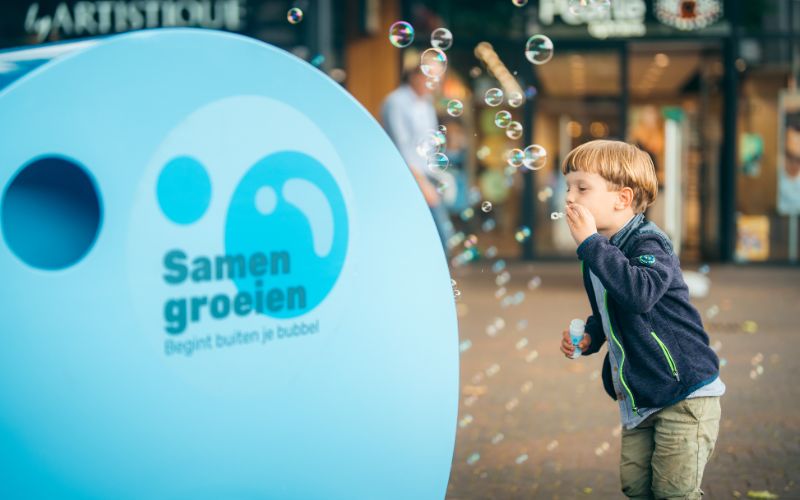 Kindje aan het bellenblazen voor de bubbelbox