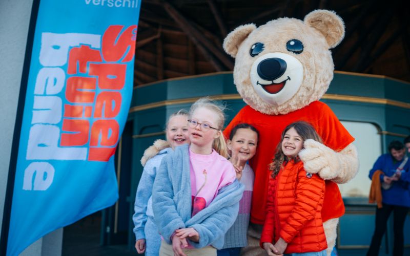 Buzzy de Beer samen op de foto met kinderen