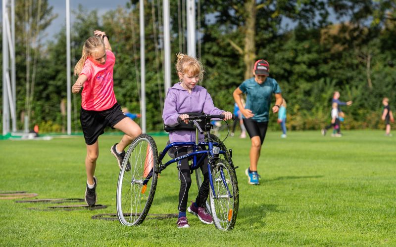 Keet op haar runningframe aan het sporten met andere kinderen