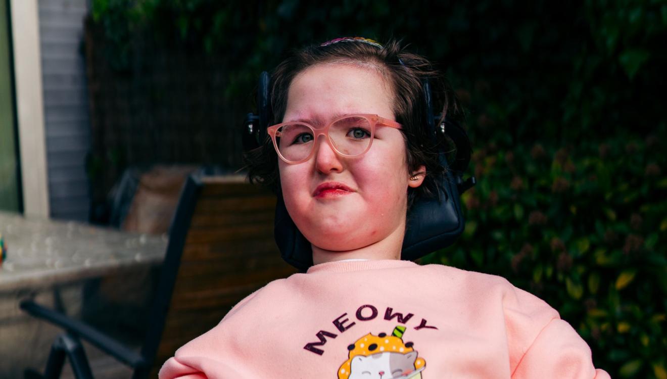 Joana zit buiten in haar rolstoel