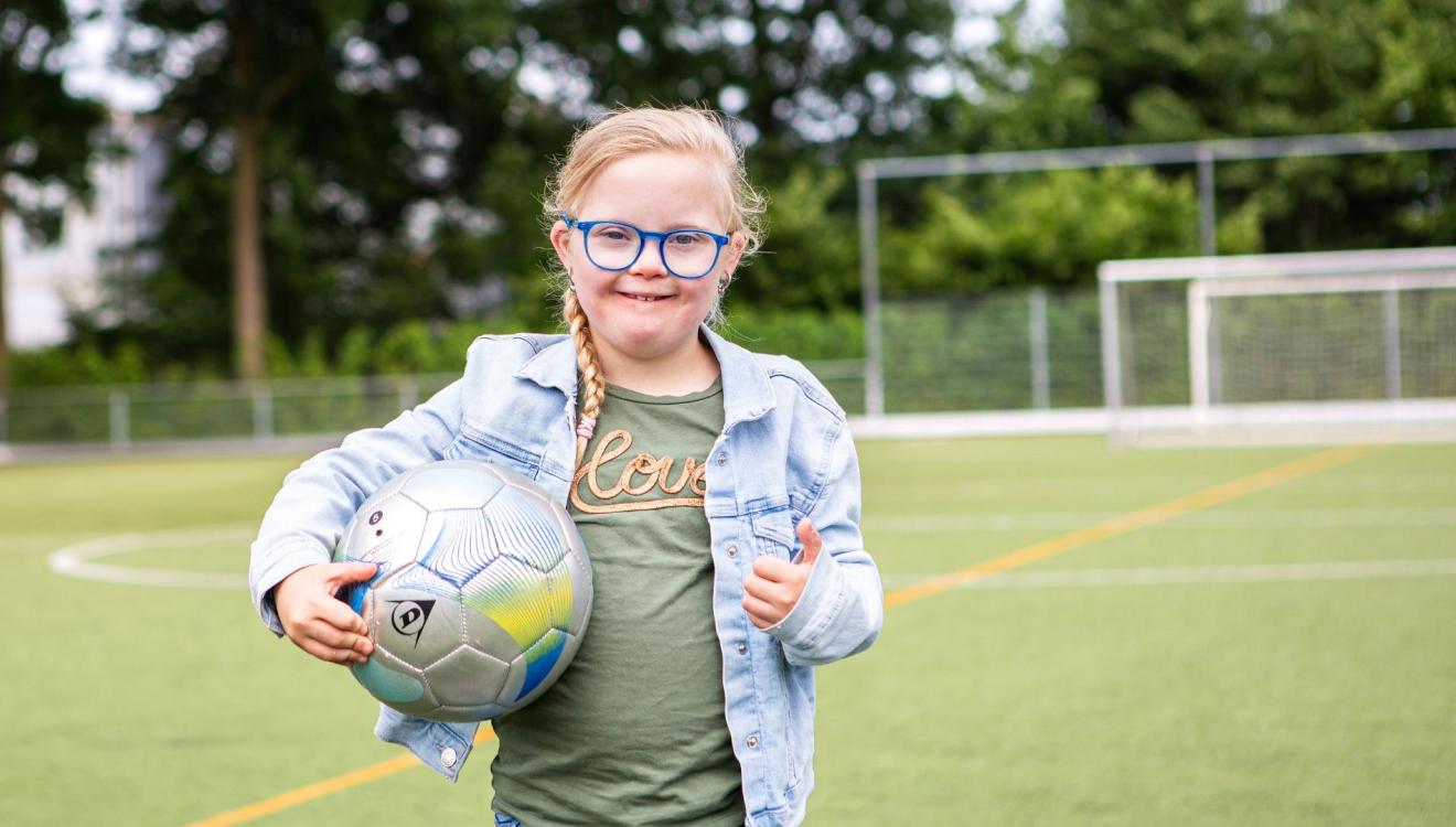 Lotte steekt haar duim omhoog en heeft de voetbal in haar hand