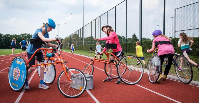 Framerunners en kinderen zonder beperking op de atletiekbaan