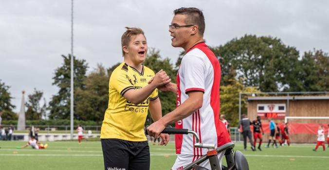 Kinderen met een handicap aan het voetballen tijdens een Bijzondere Eredivisie wedstrijd