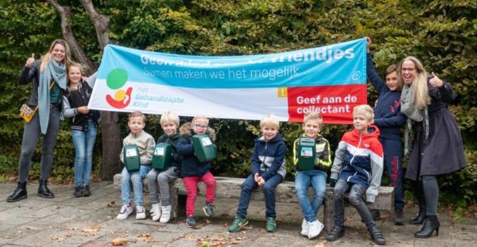 Collectevrijwillger Sabine met kinderen voor een spandoek