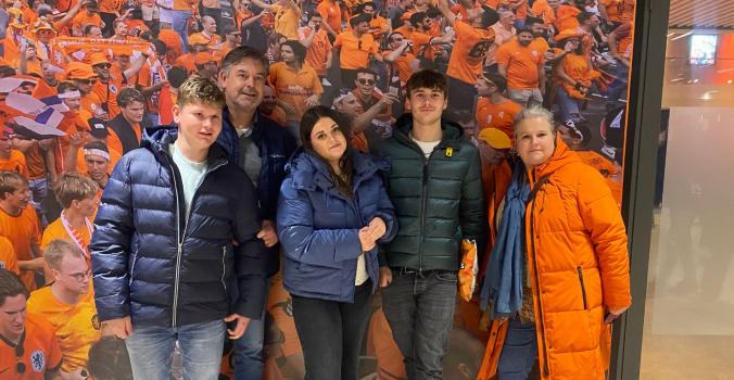 Niels en zijn familie voor een fotowand van Oranje