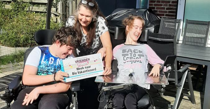 Tweeling Melvin en Thanisha met een cheque van de VriendenLoterij in hun handen