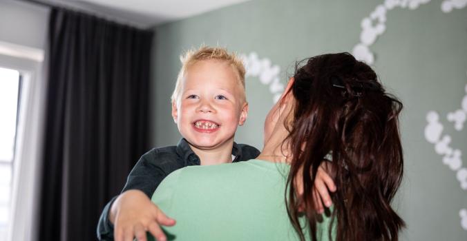 Jayce die wordt opgetild door zijn moeder Nadine