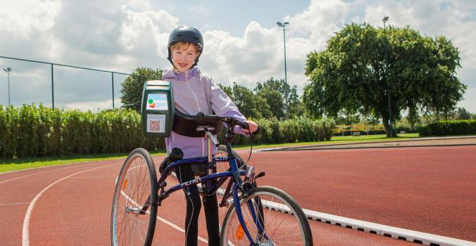 Keet op haar runningframe met een collectebus in haar hand