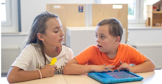 Kind zonder beperking helpt kind met beperking in de klas