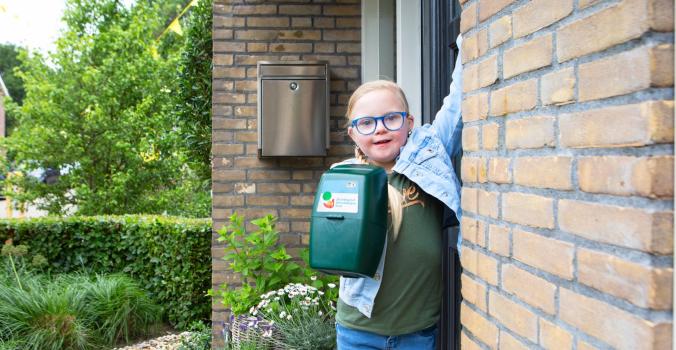 Lotte met een collectebus in de hand die aanbelt