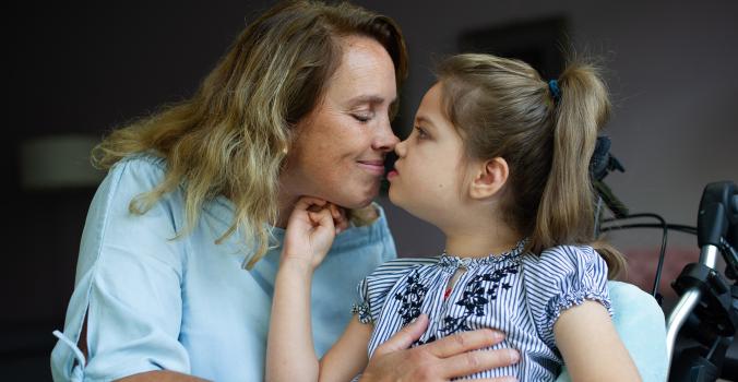 Moeder Alja geeft haar dochter Nova een kus op de neus