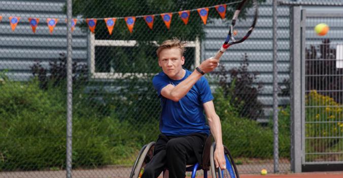 Nick aan het rolstoeltennissen