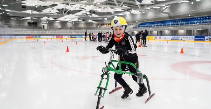 Lucas op het schaatsframe op de ijsbaan