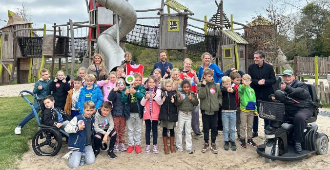 Groep kinderen met en zonder handicap voor de speeltuin