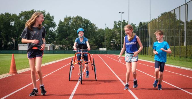 Kinderen met en zonder handicap samen aan het sporten op de atletiekbaan