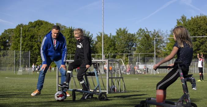 Kinderen voetballen met steun van een speciaal frame