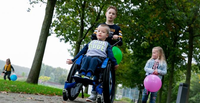 Kind duwt de rolstoel waar een kindje met een beperking in zit | Kidsproofplus