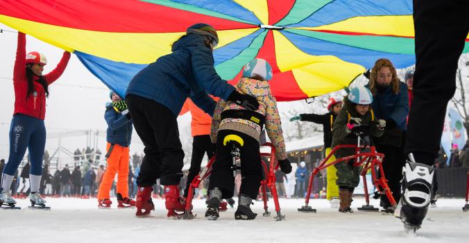 Kinderen met en zonder beperking samen aan het schaatsen op de ijsbaan op het Museumplein