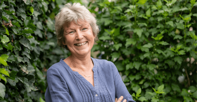 Annemieke voor een groen heg