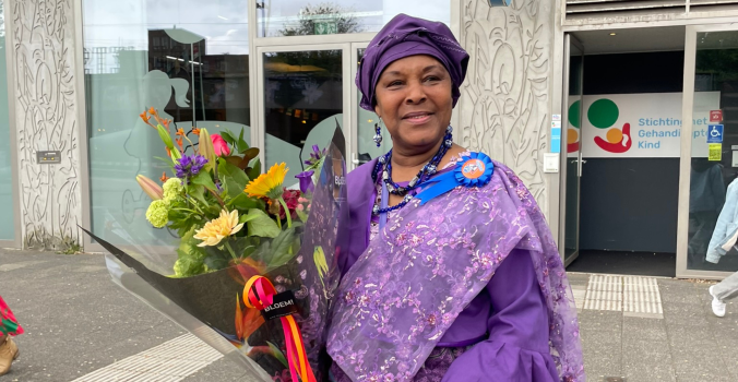 Shirley lacht en houdt een bos bloemen in haar handen tijdens haar afscheidsmoment