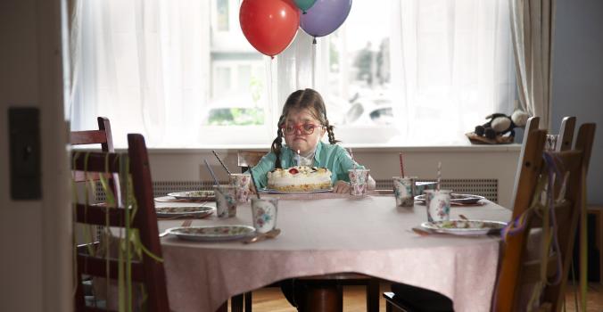 Robin tijdens haar verjaardag alleen aan tafel.