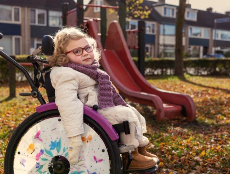 Minthe in haar rolstoel voor een ontoegankelijke speeltuin