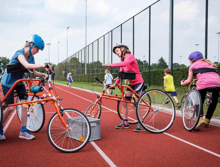 Framerunners en kinderen zonder beperking op de atletiekbaan