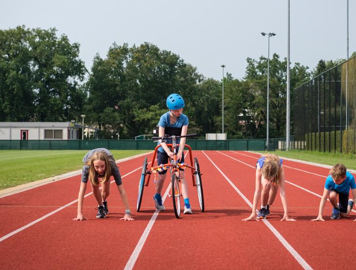 Fleur op haar runningframe en haar broertje en nichtjes aan het rennen