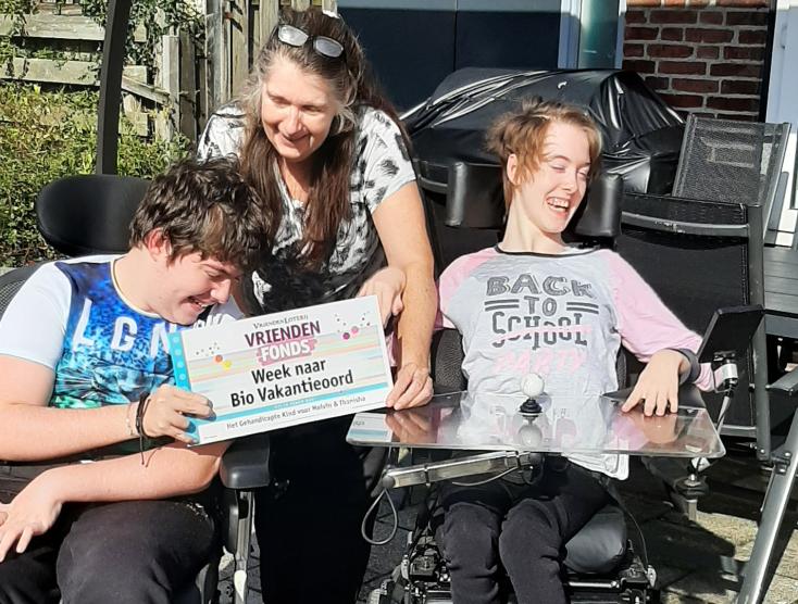 Tweeling Melvin en Thanisha met een cheque van de VriendenLoterij in hun handen