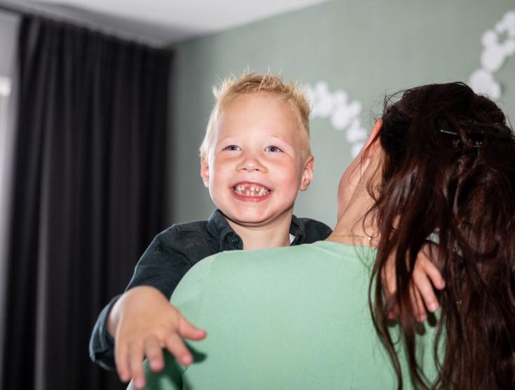 Jayce die wordt opgetild door zijn moeder Nadine