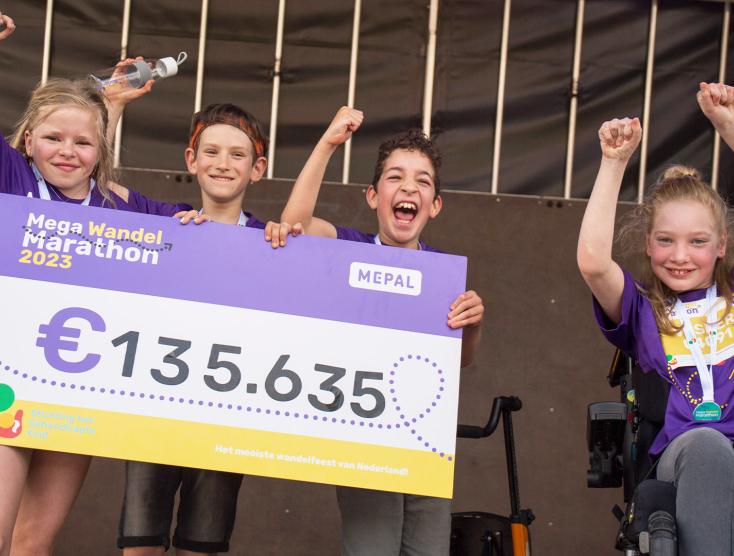 Kinderambassadeurs Feline, Art, Thomas en Vesper met de cheque van de Mega Wandel Marathon