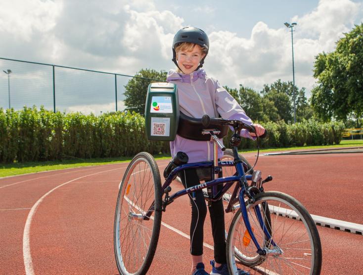 Keet op haar runningframe met een collectebus in haar hand
