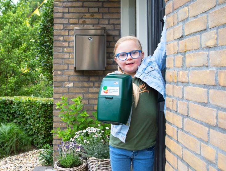 Lotte met een collectebus in de hand die aanbelt