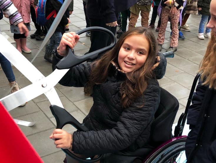 Pauline knipt met een grote schaar een lint door