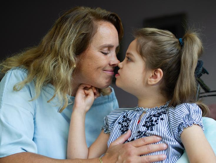 Moeder Alja geeft haar dochter Nova een kus op de neus