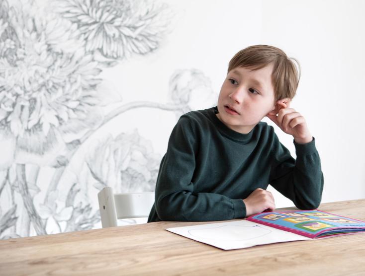 Tobias aan tafel met een boekje