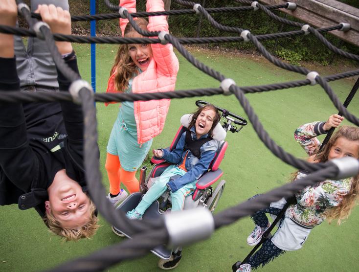 Kinderen met en zonder beperking spelen samen in op een speelplek