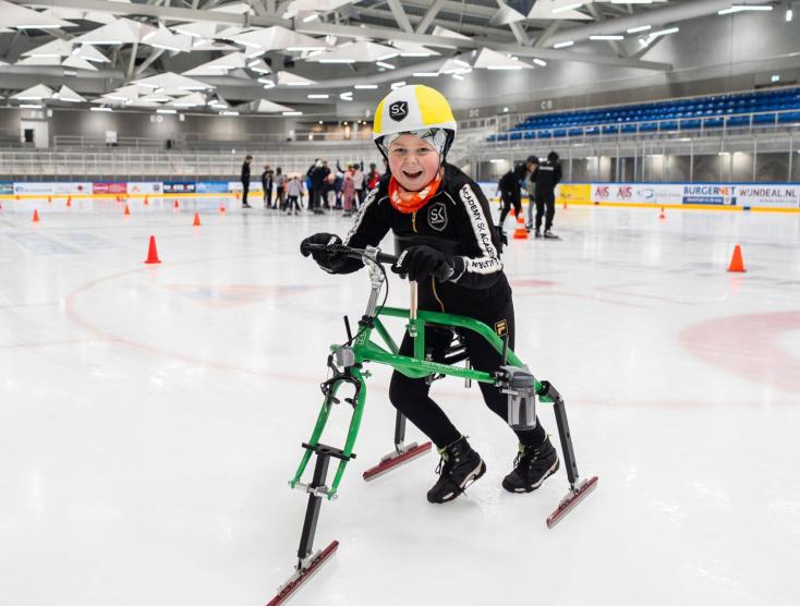 Lucas op het schaatsframe op de ijsbaan
