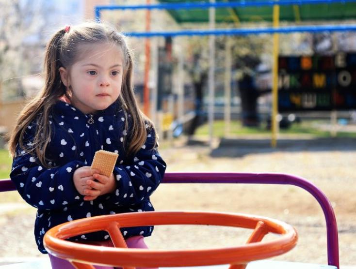 Meisje met down syndroom in de speeltuin