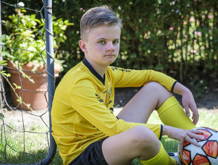 Sep zittend in het gras met een voetbal