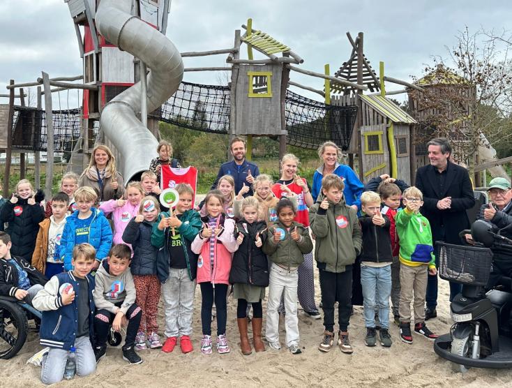 Groep kinderen met en zonder handicap voor de speeltuin