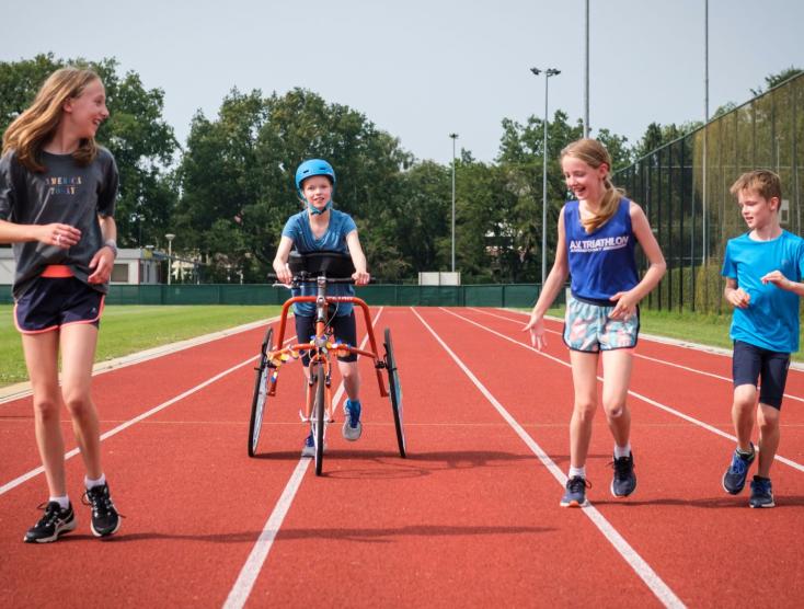 Kinderen met en zonder handicap samen aan het sporten op de atletiekbaan