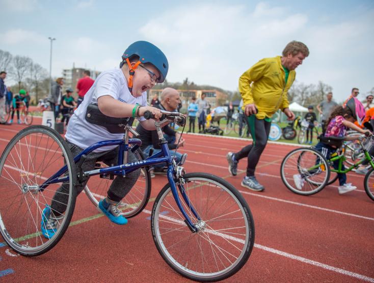 Kinderen met handicap op atletiekbaan met een Running Frame