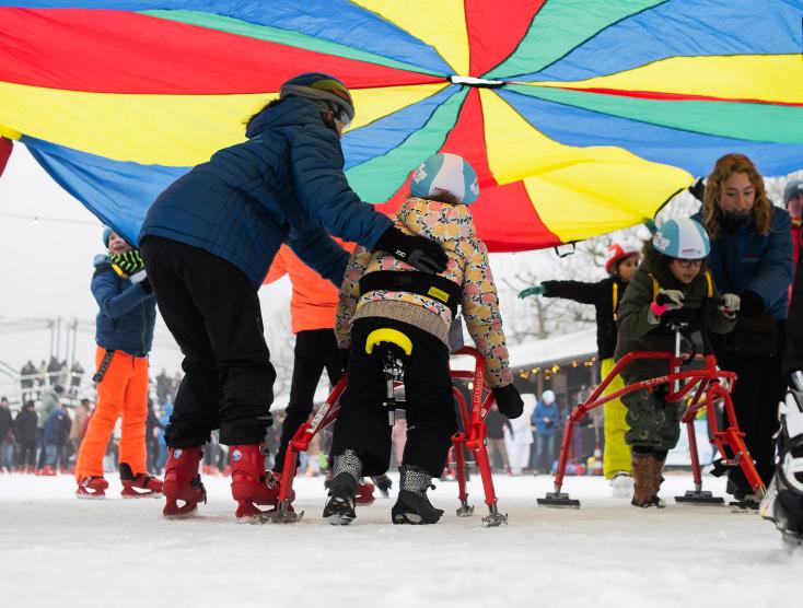 Kinderen met en zonder beperking samen aan het schaatsen op de ijsbaan op het Museumplein