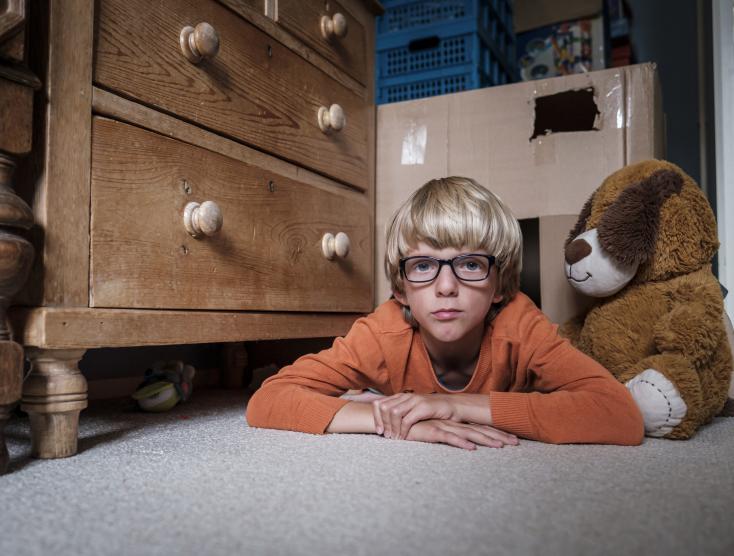 Felix speelt alleen liggend op de vloer